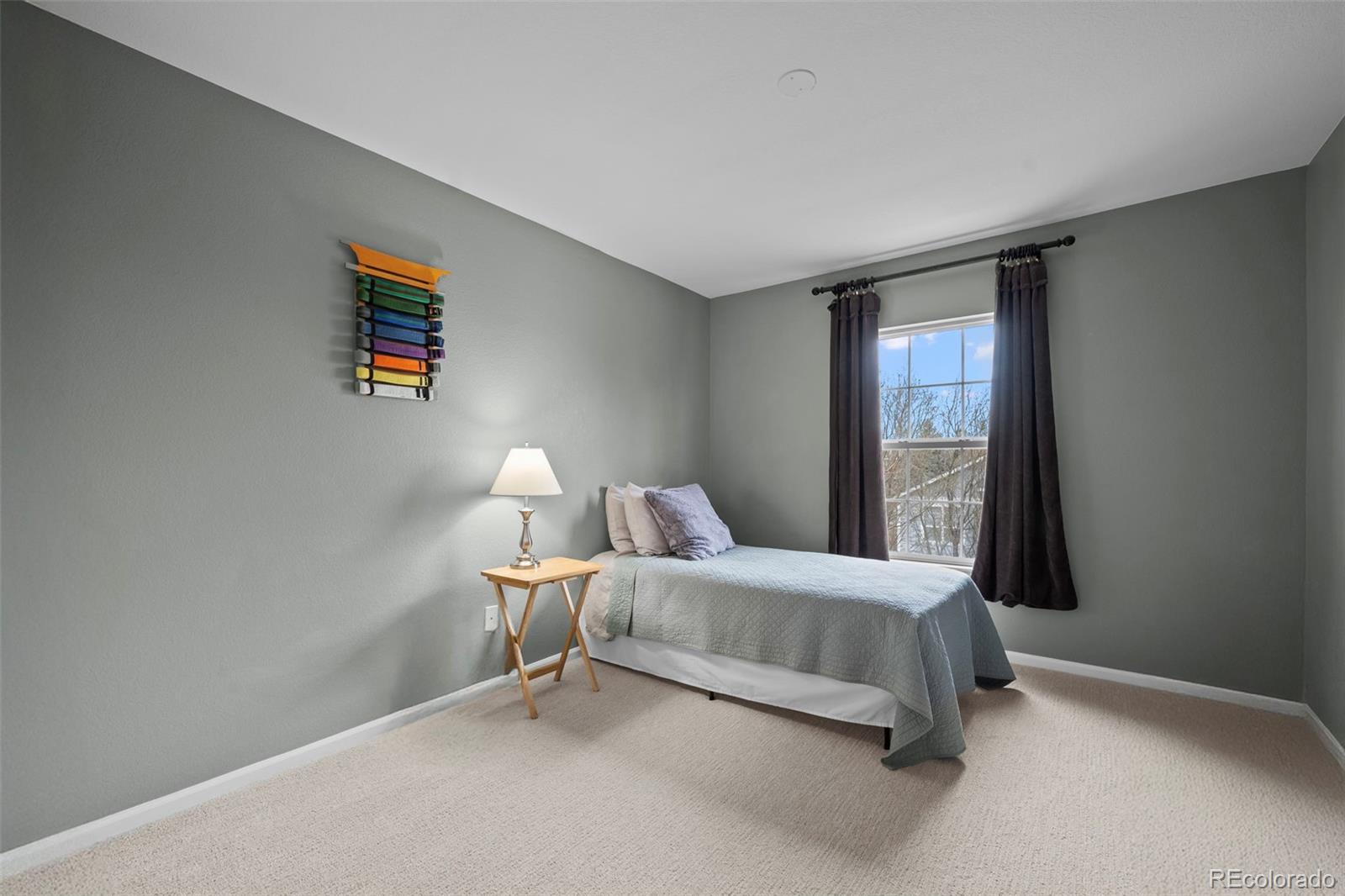 4463 Eagle River Run Broomfield, CO 80023 - Photo 25 of 44 a room with a bed and a lamp