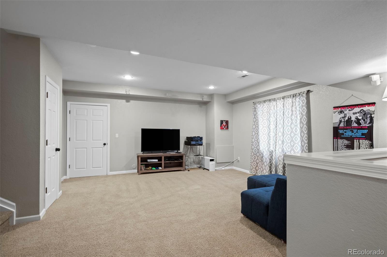 4463 Eagle River Run Broomfield, CO 80023 - Photo 29 of 44 a living room with furniture and a flat screen tv