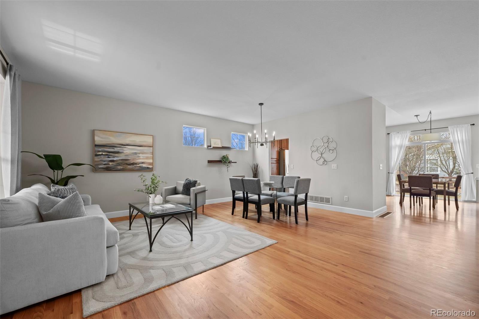 4463 Eagle River Run Broomfield, CO 80023 - Photo 9 of 44 a living room with furniture and a dining table with wooden floor