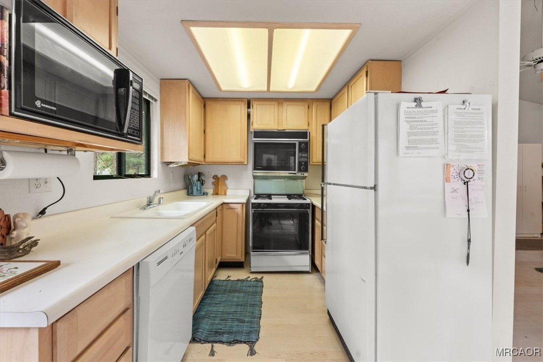 148 Crystal Lake Road Big Bear Lake, CA 92315 - Photo 12 of 29 a kitchen with stainless steel appliances a refrigerator sink and microwave
