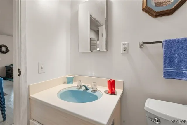 a bathroom with a sink toilet and a mirror