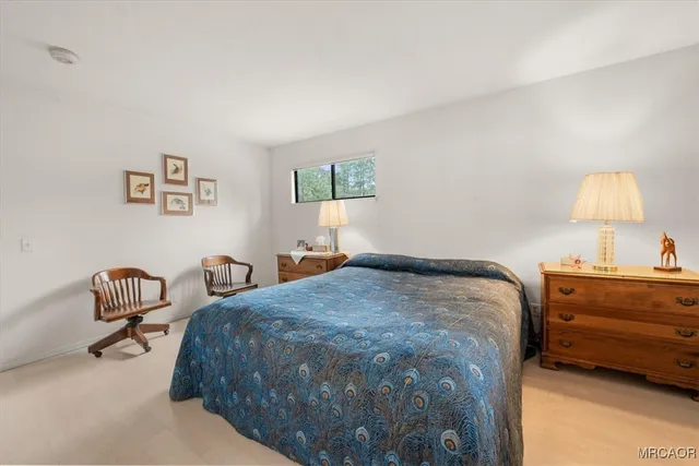 a bed sitting in a bedroom next to a lamp