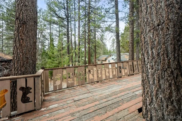 a balcony with wooden floor and trees