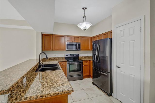 a kitchen with stainless steel appliances granite countertop a refrigerator stove and sink