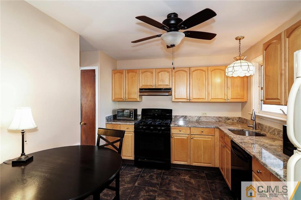 20 Barnett Road Lawrence Township, NJ 08648 - Photo 12 of 27 a kitchen with a chandelier a sink stainless steel appliances and cabinets