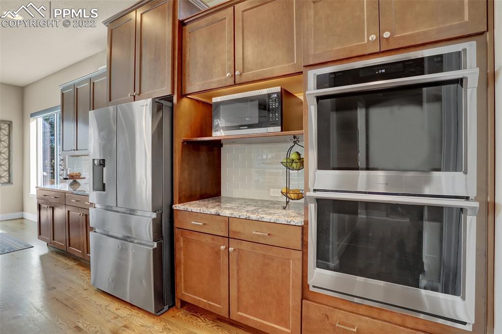 1435 Catnap Lane Monument, CO 80132 - Photo 11 of 47 a kitchen with stainless steel appliances granite countertop a refrigerator and a stove top oven