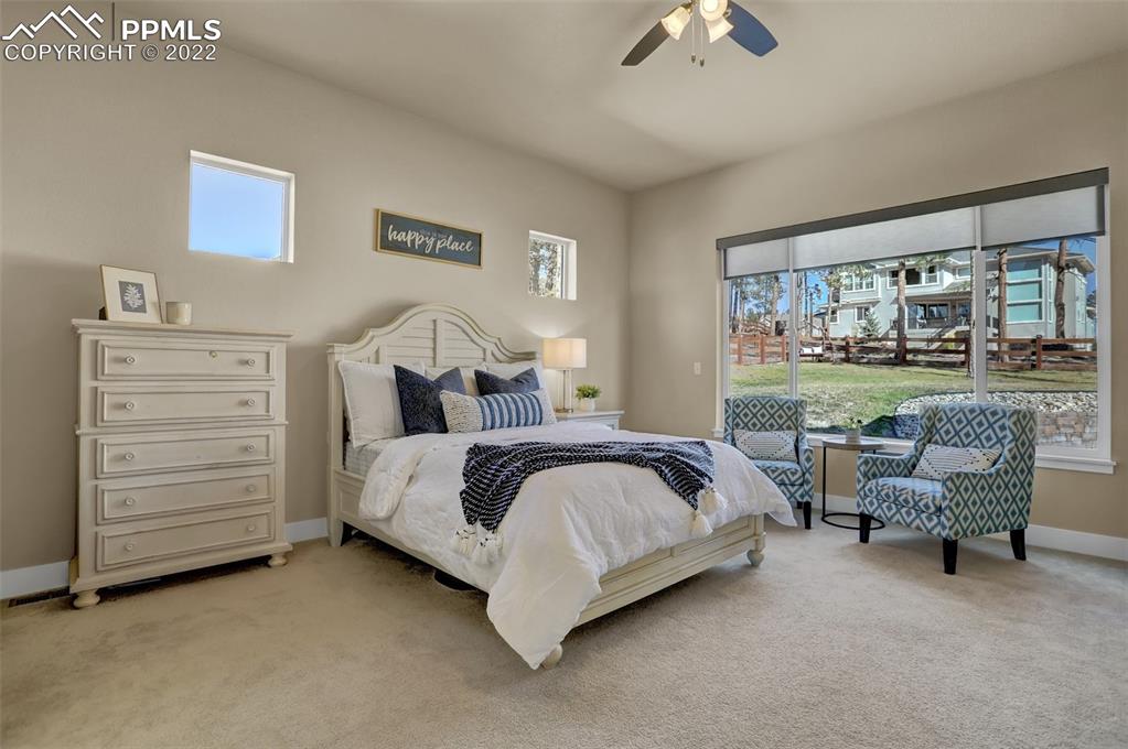 1435 Catnap Lane Monument, CO 80132 - Photo 14 of 47 a bedroom with a bed and a chandelier
