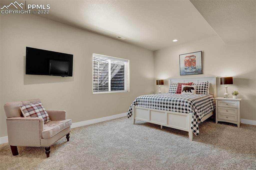 1435 Catnap Lane Monument, CO 80132 - Photo 33 of 47 a bedroom with a bed and a flat screen tv