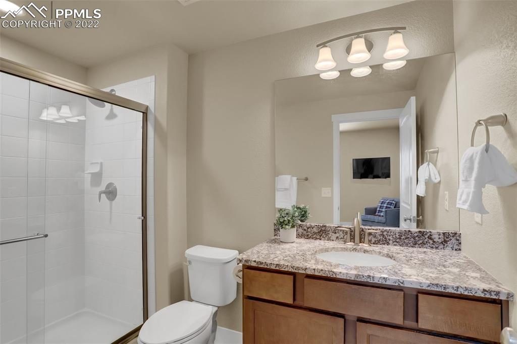 1435 Catnap Lane Monument, CO 80132 - Photo 35 of 47 a bathroom with a granite countertop sink toilet and shower