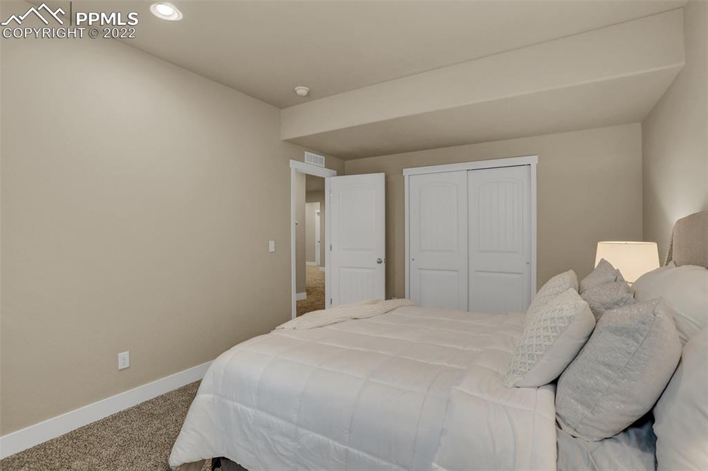 1435 Catnap Lane Monument, CO 80132 - Photo 37 of 47 a bedroom with a bed and a lamp