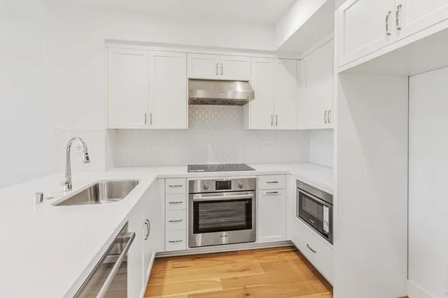 a kitchen with white cabinets and appliances