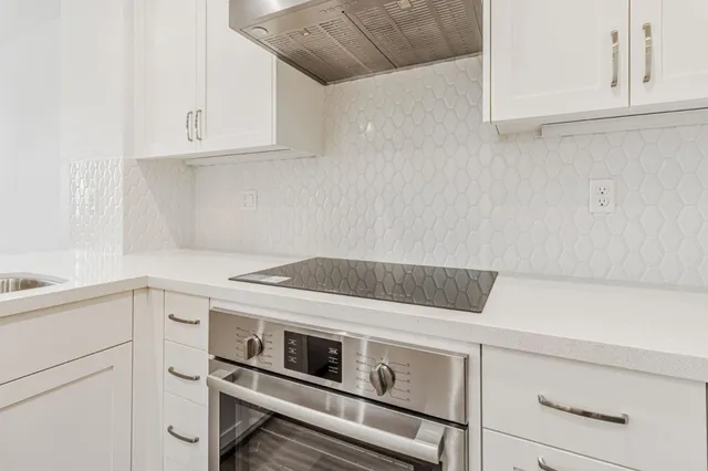 a kitchen with white cabinets and white appliances