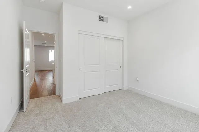 an empty room with closet and a hallway