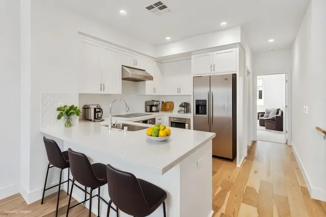a kitchen with a refrigerator a stove and a sink