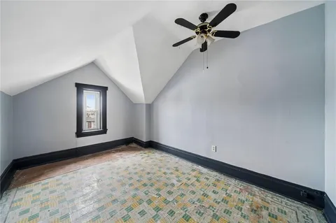 a view of an empty room and window with a chandelier fan