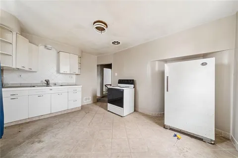 a kitchen with a white stove top oven and white cabinets