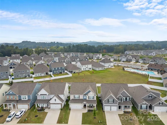 an aerial view of residential houses with outdoor space and lake view