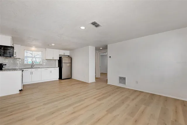 a view of a kitchen with a sink and a refrigerator