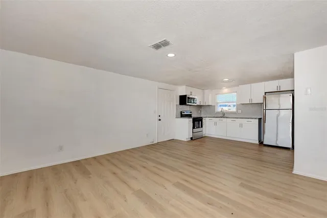 a view of a kitchen with a sink wooden floor and a window