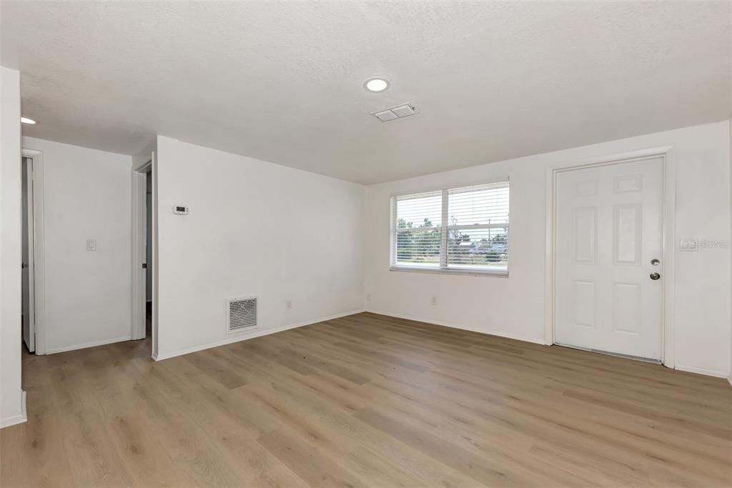 1601 Faust Drive, Unit B Englewood, FL 34224 - Photo 18 of 19 an empty room with wooden floor and windows