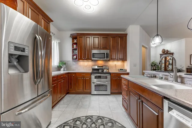 a kitchen with stainless steel appliances granite countertop a refrigerator stove and sink