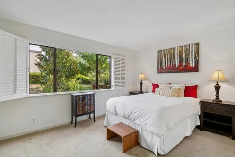 a bedroom with a bed and a large window