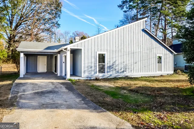 a view of a house with backyard and trees