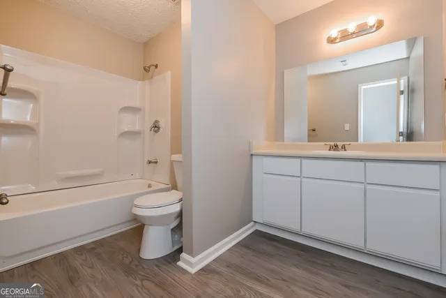 a bathroom with a sink toilet a mirror and shower
