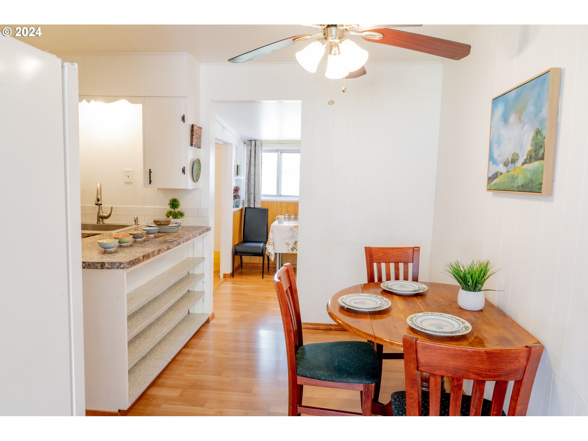 17141 Southeast Stephens Street Portland, OR 97233 - Photo 6 of 27 a open kitchen with stainless steel appliances kitchen island granite countertop a table chairs and a refrigerator