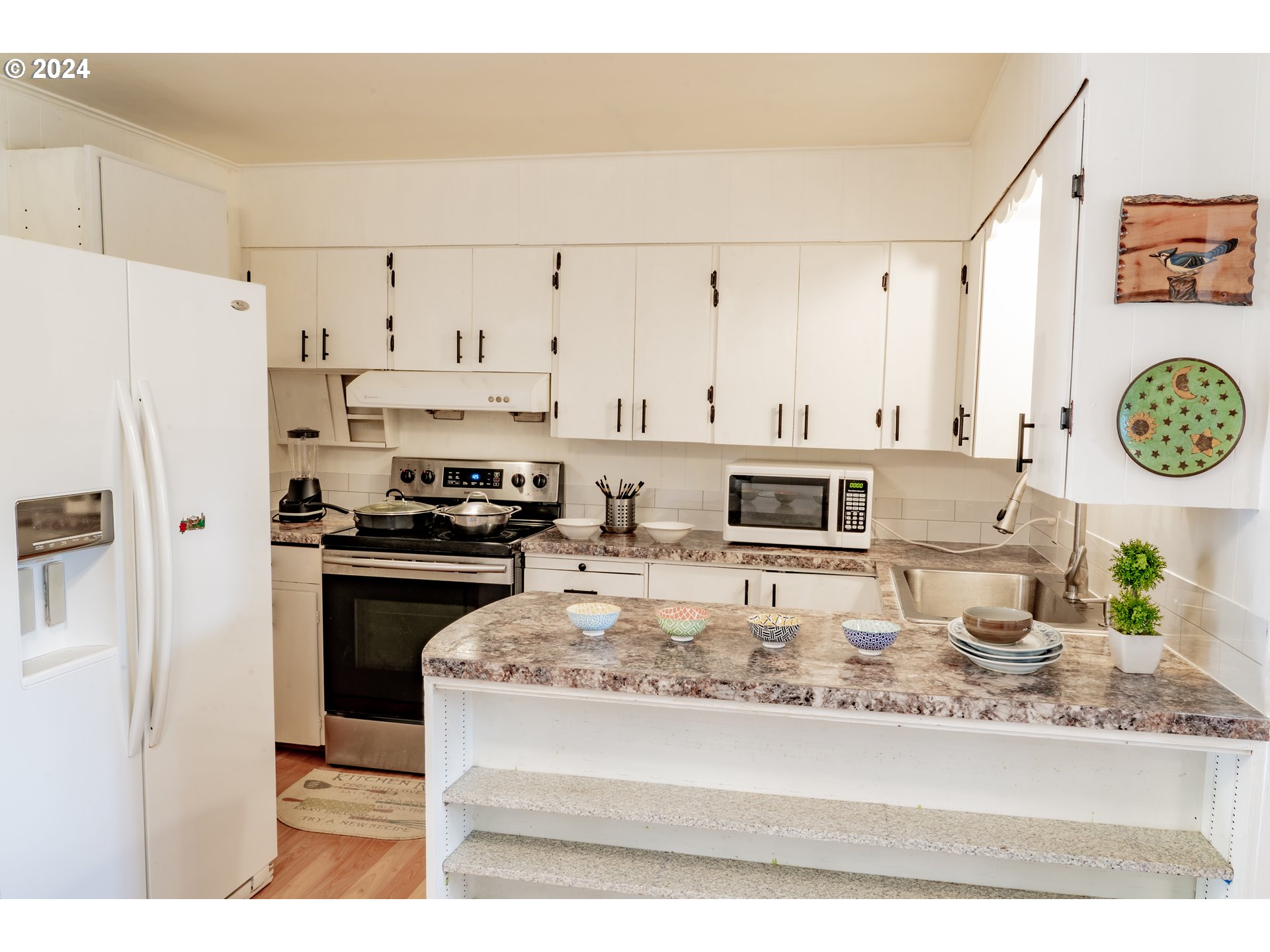 17141 Southeast Stephens Street Portland, OR 97233 - Photo 8 of 27 a kitchen with stainless steel appliances granite countertop a stove a refrigerator a sink and white cabinets with wooden floor