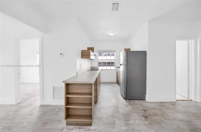 a kitchen with stainless steel appliances a refrigerator and cabinets