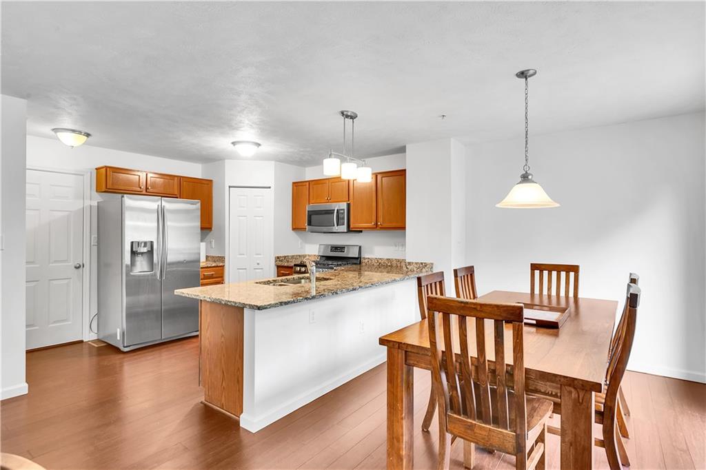 6439 Lindsey Lane Export, PA 15632 - Photo 16 of 39 a kitchen with stainless steel appliances granite countertop a stove a refrigerator a kitchen island with a dining table and chairs