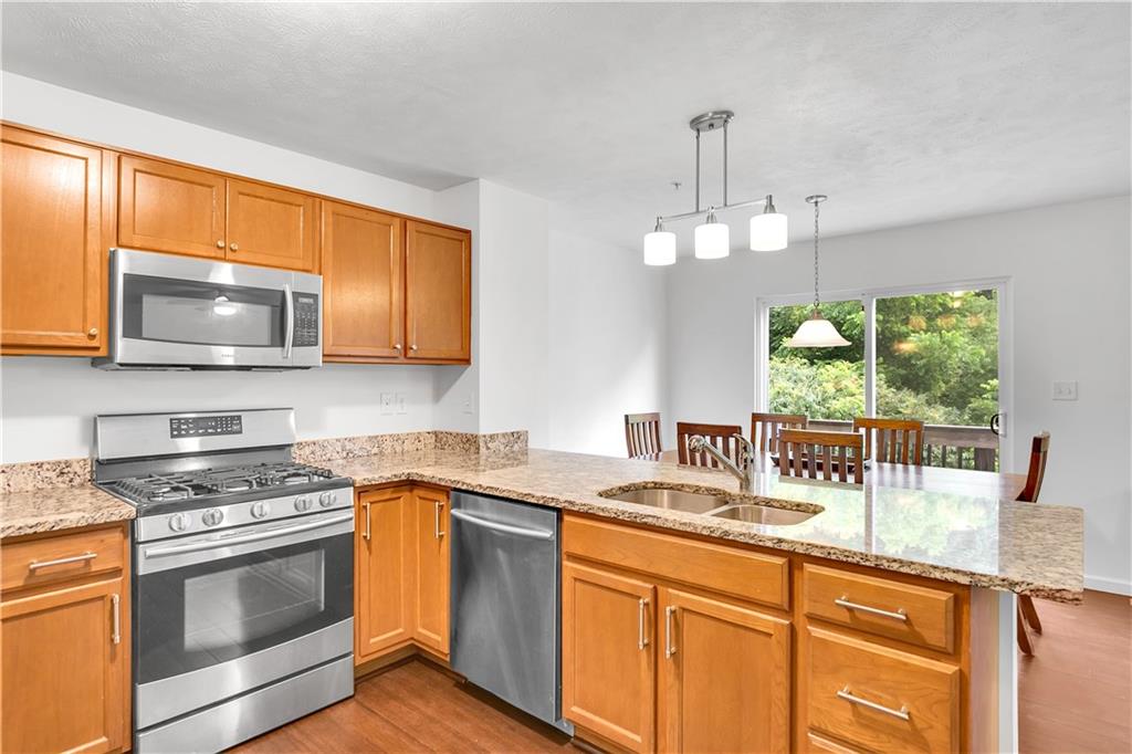 6439 Lindsey Lane Export, PA 15632 - Photo 19 of 39 a kitchen with stainless steel appliances granite countertop a sink a stove a microwave oven with cabinets and wooden floor