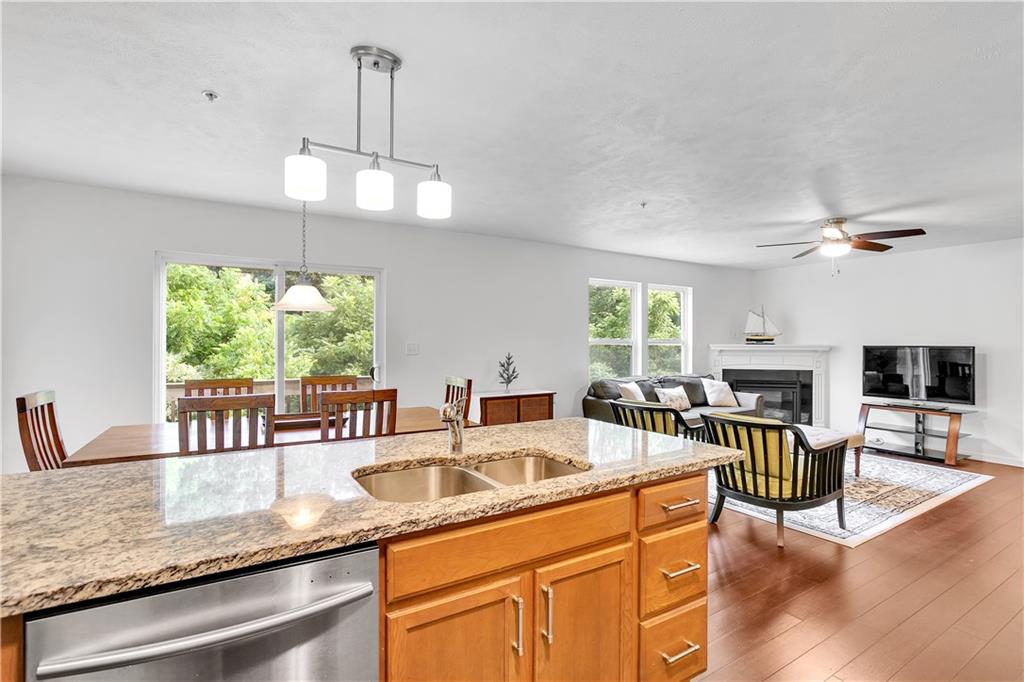 6439 Lindsey Lane Export, PA 15632 - Photo 20 of 39 a kitchen with granite countertop a stove a sink a dining table and chairs with wooden floor