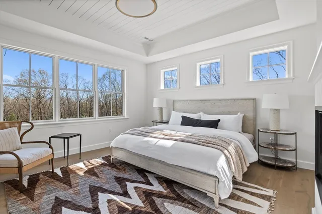 a bedroom with a bed a couch and large window