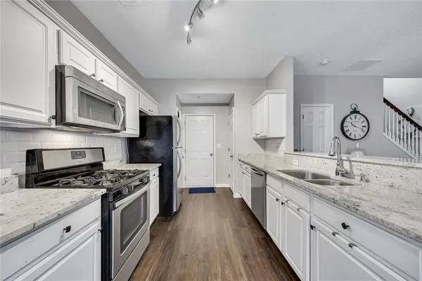 a kitchen with granite countertop a sink a stove oven and cabinets