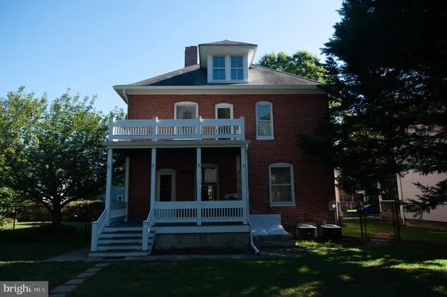 a view of a house with backyard and a tree
