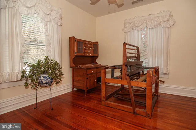 a room with wooden floor and windows