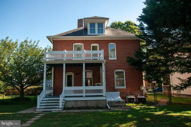 a view of a yard in front of a house with large trees