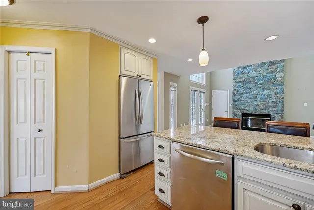 a view of an empty room with dining room and wooden floor