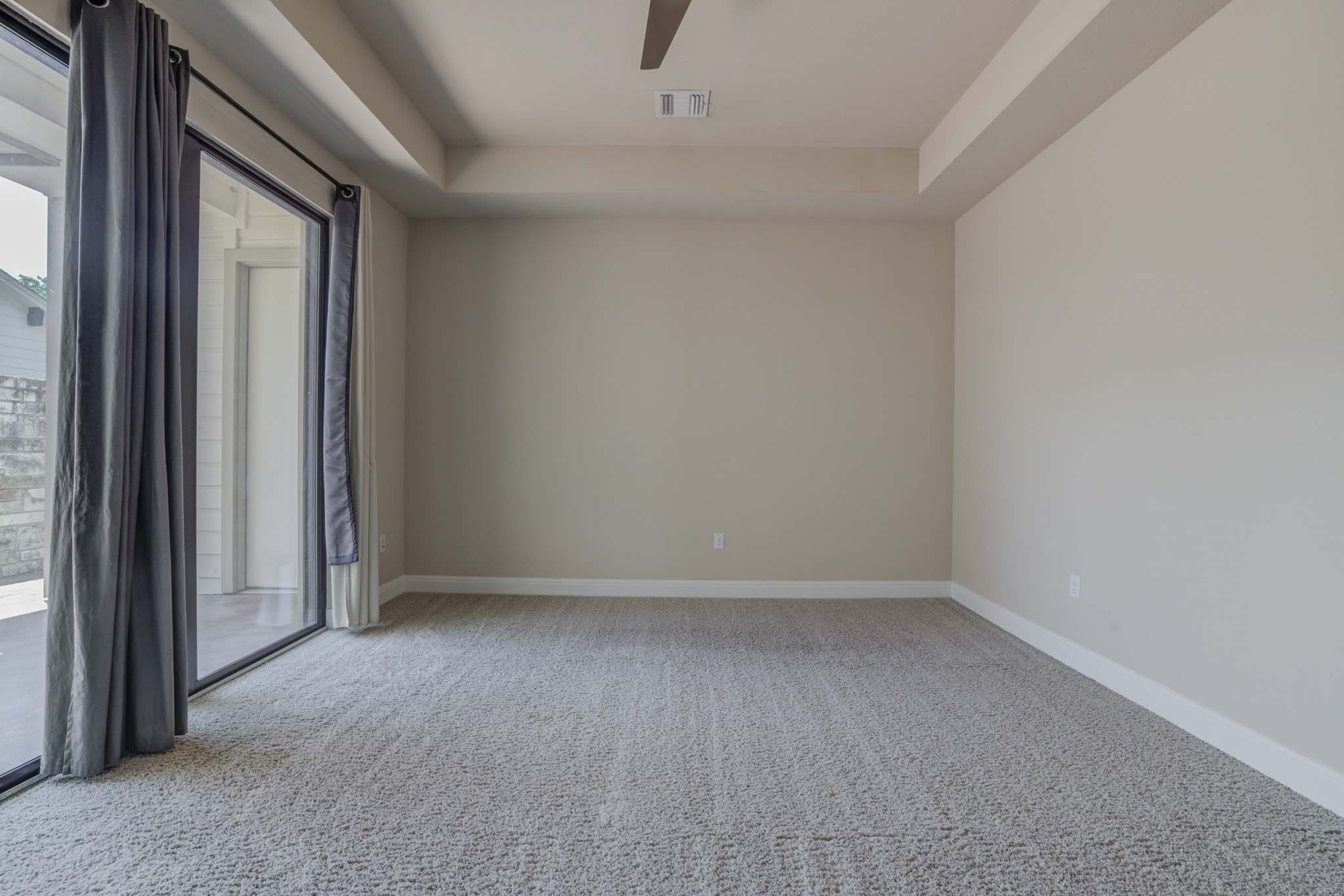 4524 Berkman Drive Austin, TX 78723 - Photo 20 of 38 Spacious owner suite featuring light-colored walls, tray ceiling, and neutral carpet flooring