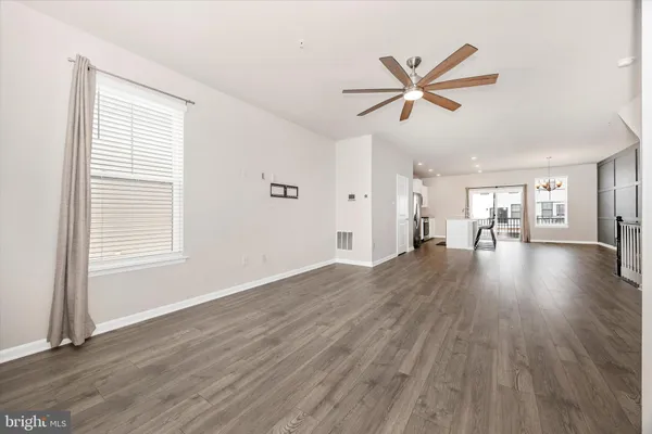 a view of a livingroom with wooden floor and a ceiling fan