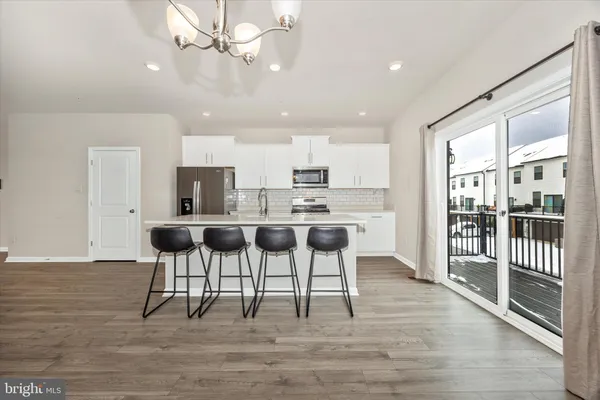 a kitchen with stainless steel appliances kitchen island granite countertop a dining table chairs and granite counter tops