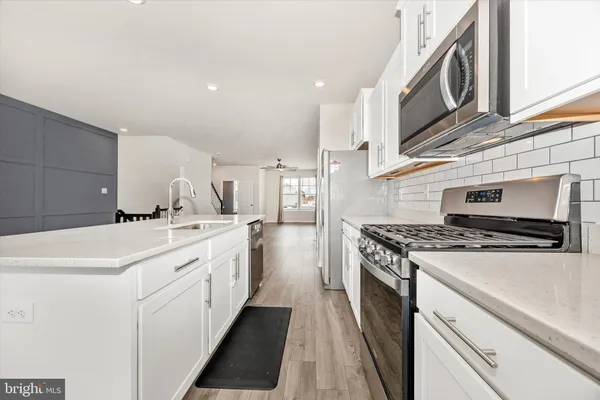 a kitchen with a stove sink and cabinets