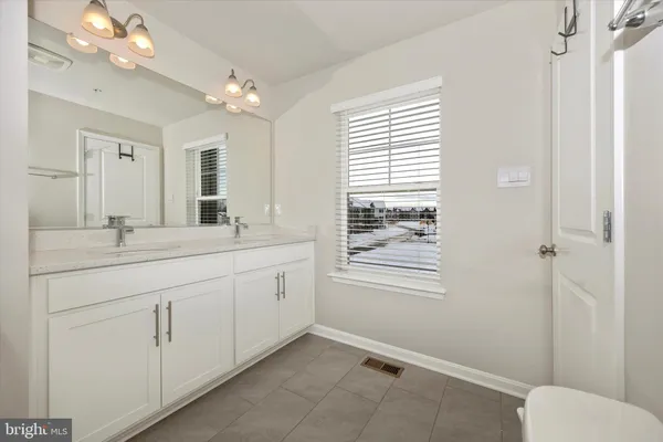 a bathroom with a double vanity sink and a mirror