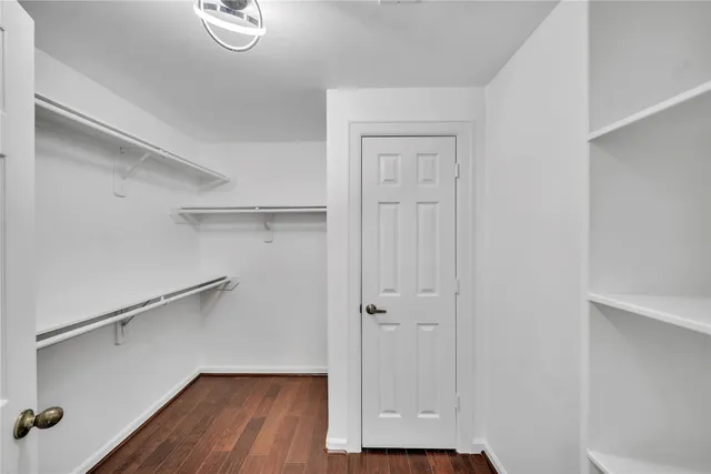 a view of walk in closet with wooden floor