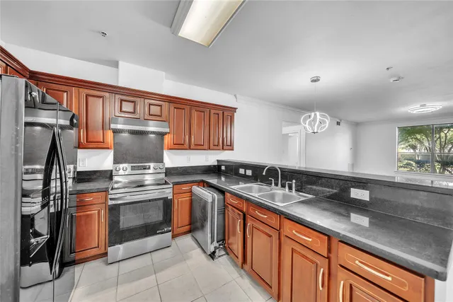 a kitchen with stainless steel appliances granite countertop a sink stove and refrigerator