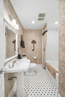 a bathroom with a sink a toilet a mirror and shower