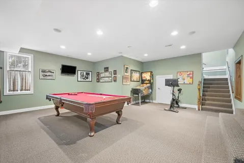 a room with furniture pool table and windows