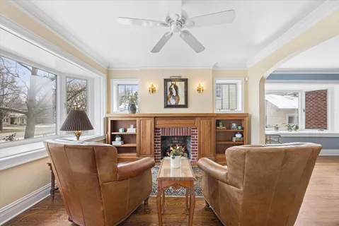 a living room with fireplace furniture and a large window